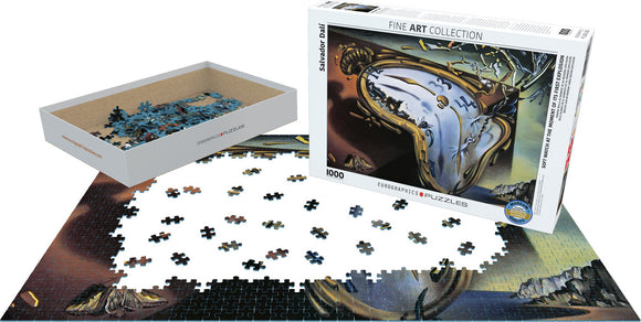 A jigsaw puzzle titled 'Soft Watch at Moment of First Explosion' by Eurographics. The puzzle features an art piece by Salvador Dali, with pieces scattered around a partially completed image showing surreal clocks and distorted landscapes. The puzzle box displays vibrant artwork and contains 1000 intricately shaped pieces for an engaging challenge.