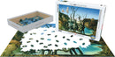 The Swans Reflecting Elephants jigsaw puzzle by Eurographics features an artistic design by Salvador Dali. The box displays the completed artwork, while the puzzle pieces are partially assembled on a table, showcasing vibrant colors and intricate details. The puzzle has 1000 pieces and is presented in a sturdy box for storage.