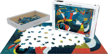 Swallow; Love by Joan Miró jigsaw puzzle by Eurographics. The puzzle features vibrant colors and abstract designs, currently displayed with pieces scattered on a surface. The box is shown partially open next to the puzzle pieces.