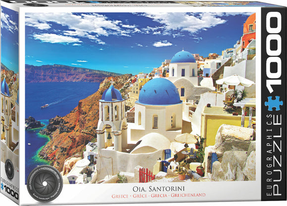 Eurographics jigsaw puzzle titled 'Oia, Santorini, Greece' featuring a vibrant coastal landscape with iconic white buildings and blue domes under a bright sky. The puzzle contains 1000 pieces, perfect for capturing the beauty of Santorini.