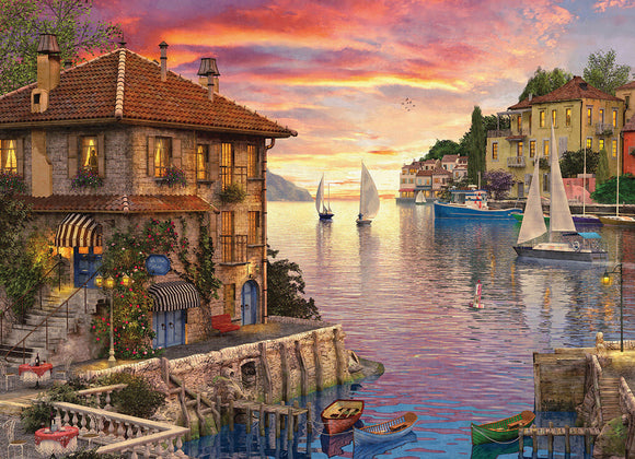 A detailed jigsaw puzzle featuring a picturesque Mediterranean harbor scene. The image showcases charming stone buildings with flower-filled balconies, colorful boats bobbing in a serene waterfront, and a stunning sunset casting vibrant hues across the sky and water. Perfect for puzzle lovers and home décor enthusiasts alike, 'Mediterranean Harbor' by Dominic Davison captures the essence of coastal tranquility.