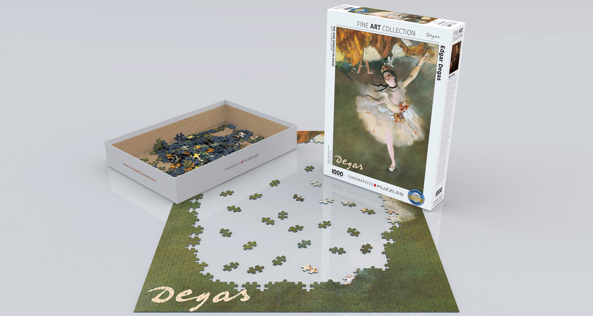 A beautifully designed jigsaw puzzle featuring 'Ballerina' by Edgar Degas. The image shows the puzzle pieces scattered around the partially completed artwork design on a flat surface. The box is displayed on the side, showcasing its elegant artwork and the Eurographics brand. The puzzle consists of 1000 pieces, ideal for art enthusiasts and puzzle lovers alike.