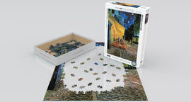 A jigsaw puzzle featuring 'Café Terrace at Night' by Vincent van Gogh. The box of the puzzle is shown beside a partially completed puzzle layout. The puzzle includes intricately shaped pieces and vibrant colors capturing the scene of a café illuminated under a starry night.