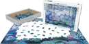 A 1000-piece jigsaw puzzle featuring Claude Monet's iconic 'Waterlilies' painting. The puzzle pieces are scattered across a partially completed image, with the box displayed beside it, showcasing vibrant blues and greens typical of Monet's style.
