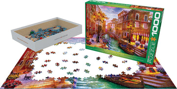 A jigsaw puzzle titled 'Sunset Over Venice' by Dominic, produced by Eurographics. The image shows a 1000-piece puzzle partially assembled with colorful pieces depicting a vibrant sunset scene over a Venetian canal, with a box and pieces scattered around.