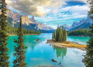 A scenic view of Maligne Lake in Alberta, showcasing vibrant turquoise waters surrounded by towering mountains and lush evergreen trees. Two people paddle a red canoe across the lake under a partly cloudy sky.