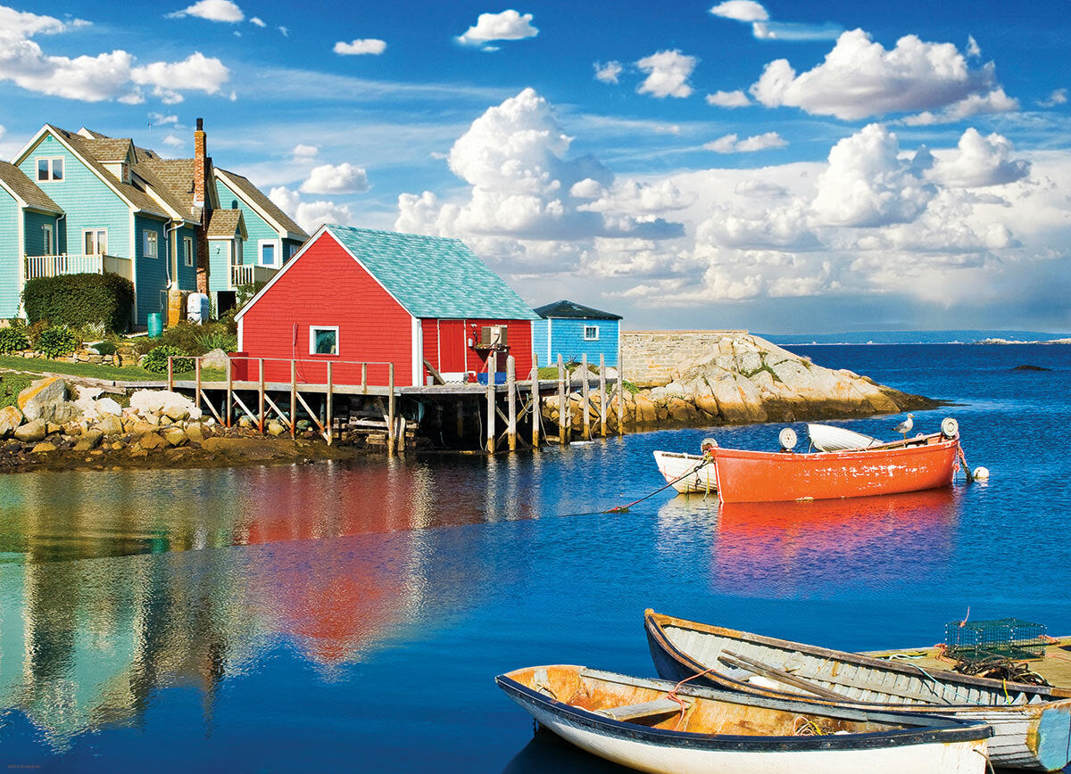 A vibrant jigsaw puzzle featuring the picturesque Peggy's Cove in Nova Scotia. The artwork showcases iconic colorful houses along the shore, with fishing boats docked in a serene harbor and a bright blue sky dotted with fluffy clouds reflecting in the water.