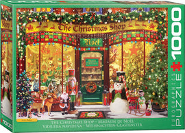 A vibrant jigsaw puzzle box featuring 'The Christmas Shop' by Eurographics. The scene depicts a festive store front, adorned with holiday decorations, Christmas trees, and cheerful characters like a snowman and nutcracker. The display window showcases a variety of holiday toys and ornaments, creating a warm, inviting atmosphere for the holiday season. Perfect for jigsaw puzzle enthusiasts and holiday decorators.