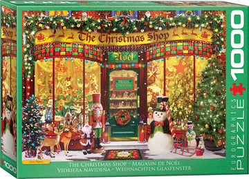 A vibrant jigsaw puzzle box featuring 'The Christmas Shop' by Eurographics. The scene depicts a festive store front, adorned with holiday decorations, Christmas trees, and cheerful characters like a snowman and nutcracker. The display window showcases a variety of holiday toys and ornaments, creating a warm, inviting atmosphere for the holiday season. Perfect for jigsaw puzzle enthusiasts and holiday decorators.