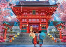 Spring Sakura Jigsaw Puzzle by Eurographics depicting a vibrant scene of a traditional Japanese temple surrounded by cherry blossoms, with two women in colorful kimonos holding decorative umbrellas, creating a serene and picturesque atmosphere perfect for puzzle enthusiasts.