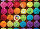 Colorful jigsaw puzzle featuring a vibrant arrangement of beautifully decorated cupcakes in various colors and frosting styles, set against a rustic wooden background.