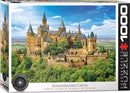 A beautifully illustrated jigsaw puzzle of Hohenzollern Castle in Germany, presented in a colorful box by Eurographics. The scene captures the majestic castle set amidst lush greenery and a bright blue sky, featuring turrets and intricate architectural details.
