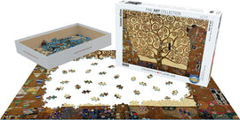 A 1000-piece jigsaw puzzle featuring Gustav Klimt's 'Tree of Life'. The artwork shows swirling patterns and a stylized tree on a golden background. The puzzle pieces are spread out on a table, with some assembled and others still in the box, showcasing the intricate details and colors of the image.