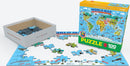 Eurographics Illustrated Map of the World jigsaw puzzle featuring colorful geographical illustrations of continents, animals, and landmarks. The 100-piece puzzle is partially assembled, with several pieces in a white box nearby. The vibrant box displays the title and age recommendation, making it an educational and fun activity for children aged 5 and up.