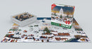 The 'Christmas at the Capitol' jigsaw puzzle by Eurographics shows a festive winter scene featuring the Capitol building, carriages, and people enjoying Christmas activities. The puzzle pieces are displayed on a flat surface alongside the neatly organized box.