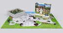 The Yoga Park jigsaw puzzle by Eurographics features a vibrant scene depicting adorable animals, including dogs and cats, practicing yoga in a green park. The image shows some pieces of the puzzle on a table, with the puzzle box displayed prominently in the background.