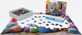 A jigsaw puzzle titled 'Knittin' Kittens' by EuroGraphics, featuring a colorful scene with kittens and yarn balls. The puzzle pieces are spread out on a table, with the box and another montage showing the image of the completed puzzle. It includes 500 large pieces, ideal for puzzlers of all ages.