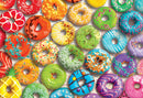 A vibrant collection of colorful, decorated donuts displayed in a visually appealing arrangement. The donuts feature various toppings like sprinkles, icing, and fruit slices in a rainbow of colors, creating a fun and eye-catching jigsaw puzzle image.