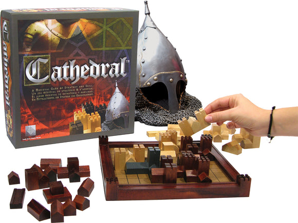 Cathedral game by Family Games Inc. featuring a medieval strategy board game. The image shows the game box, wooden building pieces in various colors, and a player placing a piece on the board, which has a checkerboard grid design. A knight helmet is displayed in the background, enhancing the medieval theme.