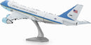 A detailed Metal Earth DIY model kit of Air Force One, featuring intricate metal parts that replicate the iconic presidential aircraft. The model is elevated on a sleek stand, showcasing its realistic design and color scheme, including the blue and white exterior, United States of America text, and distinct tail markings. Ideal for aviation enthusiasts and model makers.