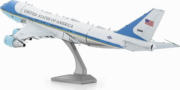 A detailed Metal Earth DIY model kit of Air Force One, featuring intricate metal parts that replicate the iconic presidential aircraft. The model is elevated on a sleek stand, showcasing its realistic design and color scheme, including the blue and white exterior, United States of America text, and distinct tail markings. Ideal for aviation enthusiasts and model makers.