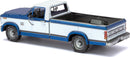 A detailed model kit of a 1982 Ford F-150 pickup truck by Fascinations. The model features a two-tone blue and white exterior, intricate detailing on the wheels, and an open truck bed, making it a perfect DIY project for automotive enthusiasts.