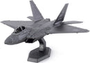 A detailed Metal Earth F-22 Raptor plane model kit from Fascinations, showcasing intricate metal craftsmanship and assembly pieces. The model displays a sleek design with realistic features such as panel lines, cockpit details, and a sturdy base for display.
