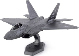 A detailed Metal Earth F-22 Raptor plane model kit from Fascinations, showcasing intricate metal craftsmanship and assembly pieces. The model displays a sleek design with realistic features such as panel lines, cockpit details, and a sturdy base for display.