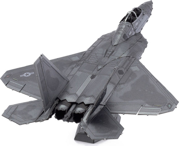 A detailed metal model kit of the F-22 Raptor plane by Fascinations. The model showcases intricate designs, featuring the plane's wings, cockpit, and engines, all in a metallic finish, perfect for DIY enthusiasts.