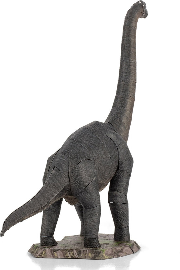 A detailed Metal Earth Brachiosaurus DIY kit by Fascinations. The model features intricate slits and textures, showcasing the dinosaur's long neck and sturdy legs. It is positioned on a rectangular base with a textured surface, resembling a natural habitat.