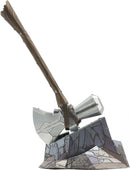 Metal Earth: Stormbreaker DIY kit, featuring an intricately designed metal model of Thor's iconic weapon, the Stormbreaker axe, displayed on a rocky base. The model showcases metallic textures and details, with a brown wooden handle and a silver axe blade, perfect for fans of Marvel and DIY enthusiasts.
