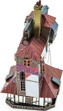 A detailed model of The Burrow from Metal Earth, showcasing a multi-layered cottage with vibrant red, blue, and silver roofs, intricate window designs, and a charming chimney. This DIY kit invites creativity and craftsmanship, perfect for enthusiasts.