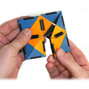 A person holding Ivan's Hinge, a colorful mechanical puzzle made by Fat Brain Toys. The puzzle features interlocking geometric shapes in blue, orange, and black. It challenges users to manipulate the pieces into various configurations, promoting problem-solving skills and fine motor development.
