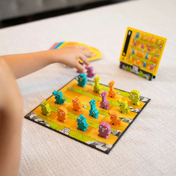 A colorful mechanical puzzle game titled 'Zoo Rendezvous' made by Fat Brain. The game features various animal-shaped pieces arranged on a vibrant board, with a player's hand reaching out to interact with the pieces. The background displays a playful design perfect for engaging young minds in strategy and problem-solving.
