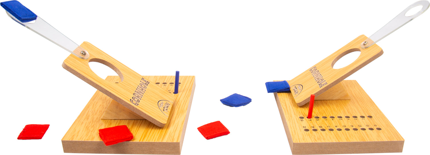 Teeny Town Cornhole Toss game featuring two wooden cornhole toss platforms with distinct launching levers for tossing colored bean bags. The game includes red and blue bean bags scattered around the platforms, perfect for indoor or outdoor fun. Ideal for parties and family gatherings.