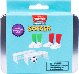 Teeny Tiny Soccer game kit featuring two miniature goals, one soccer ball, and four player figures with colorful socks. The kit offers playful activities in a compact package, ideal for soccer enthusiasts and children.