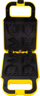 A vibrant yellow Pac Man Waffle Maker with a fun design featuring molds for iconic Pac Man characters, including the ghost shapes. The waffle maker is open, showing the intricate non-stick molds, perfect for creating deliciously themed waffles that appeal to fans of all ages.