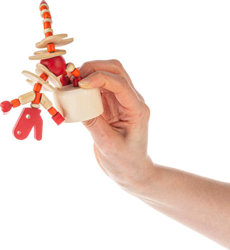 A person holding a colorful wooden dinosaur push puppet made by GAnz. The puppet features articulated limbs and a playful design, ideal for imaginative play.