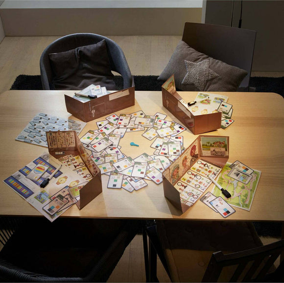 A tabletop game setup titled 'The Key Murder at the Oakdale' featuring various playing cards and tokens spread out on a wooden table. The game includes several dividers, maps, and clues, creating an engaging mystery-solving experience. The setting includes two chairs and a cozy atmosphere, enhancing the game night feel.