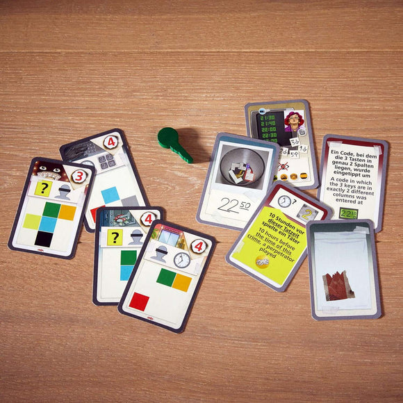 The Key Royal Star Casino game by Haba features a collection of cards with various images and symbols. There is also a green key included in the layout. The cards display numbers, puzzle elements, and clues necessary for gameplay, designed for a thrilling escape room experience.