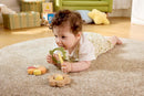 A baby chewing on a leaf teether