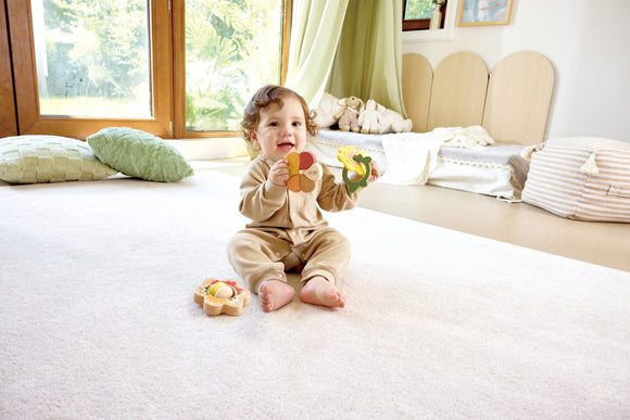 Child playing with flower-shaped teether and rattle