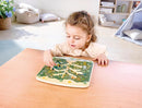 Child plays with wooden activity shaped like a tree with a stylus