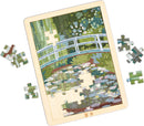 jigsaw puzzle in wooden frame depicting an illustrated bridge over a water-lily covered pond