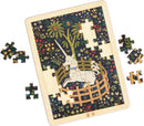 Jigsaw puzzle of a unicorn in a round wooden pen. The puzzle fits in a light wood frame