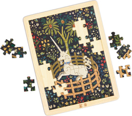 Jigsaw puzzle of a unicorn in a round wooden pen. The puzzle fits in a light wood frame