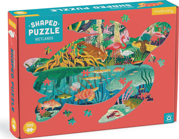 The Wetlands Shaped Puzzle by Mudpuppy features an artistic depiction of a wetland scene filled with vibrant flora and fauna. The packaging showcases the unique turtle shape of the puzzle, highlighting colorful animals like flamingos, fish, and turtles amidst lush greenery. This 300-piece jigsaw puzzle is made from recycled materials, perfect for nature enthusiasts and puzzle lovers alike.