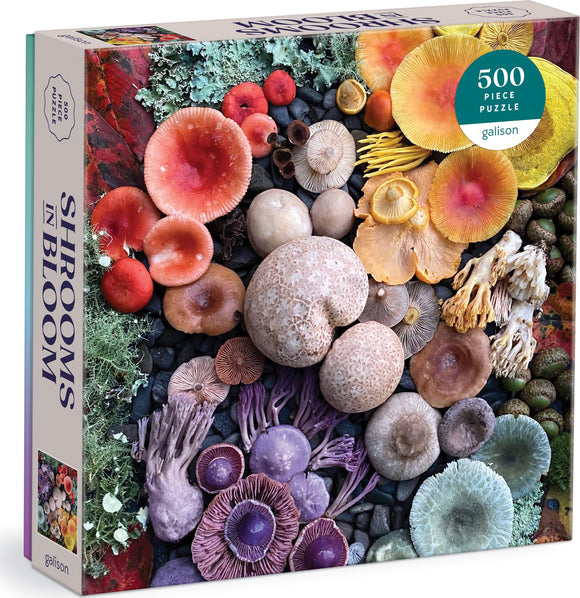 Shrooms in Bloom jigsaw puzzle by Galison featuring a vibrant collage of various mushrooms. The puzzle box shows a colorful arrangement of mushrooms, showcasing different shapes, sizes, and colors against a rocky background. It contains 500 pieces, providing an engaging challenge for puzzle enthusiasts.
