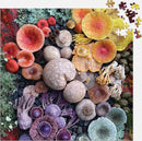 Shrooms in Bloom Jigsaw Puzzle by Galison featuring an intricate and vibrant arrangement of various mushrooms, showcasing a kaleidoscope of colors and shapes set against a dark background. The puzzle pieces are scattered around the edges, inviting you to piece together this beautiful nature-themed puzzle.