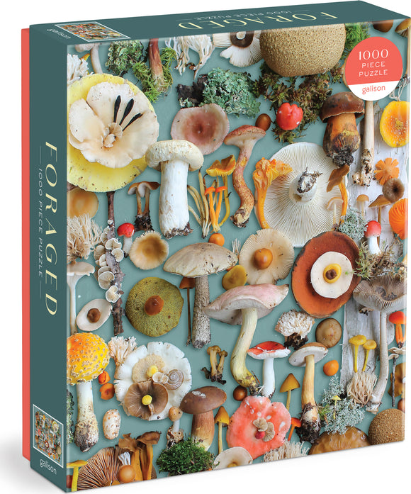 A 1000-piece jigsaw puzzle titled 'Foraged' by Galison. The puzzle features a vibrant and detailed collage of various mushrooms and foraged plants set against a soft teal background.